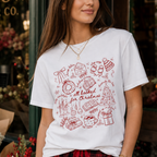 Woman wearing the All Booked for Christmas Comfort Colors 1717 graphic T-shirt featuring a cozy holiday doodle design with books, cocoa, ornaments, gifts, and festive Christmas illustrations.