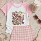 Flat lay of a pink coquette raglan baby tee featuring vintage casino cards, lucky symbols, bows and floral graphics.